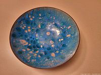 Top-down view showing bubble pattern of blue and turquoise enamel with hints of cream on the bowl interior.