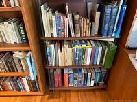 Shelf showing rows of vintage and antique books of various sizes and colors.