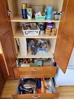 Cabinet shelves showing glasses, cocktail shaker, small glass containers, spice jars, and other kitchen items.