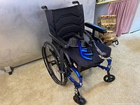 Front-angle view of assembled wheelchair on carpet