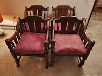 Front angle of four solid wood armchairs with purple/pink patterned seats showing the overall condition and design.