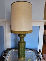 Full view of vintage 1970s green ceramic table lamp with beige fabric shade and green trim