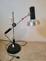Full view of vintage industrial table lamp showing base, adjustable arm, and vented metal shade.