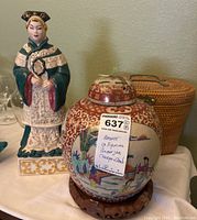 Photo showing the Asian style figurine, ginger jar on its wooden charger, and woven basket behind.
