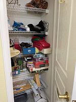 View of closet shelving showing assorted puzzles, folded linens, and rolls of shelf and cupboard liner materials.