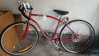 Red vintage Ross Compact bicycle with drop handlebars, front and rear fenders, black saddle, and 24-inch wheels shown from side in garage setting.