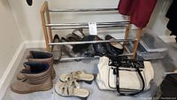 Overall lot with shoe rack holding several pairs of women's shoes, additional shoes on floor, small storage containers to right