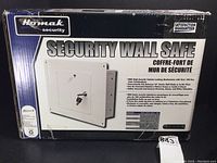Boxed Homak Security wall safe, showing front with product name and lock illustration.