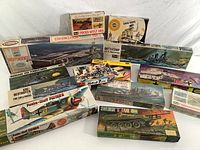 Thirteen assorted WWII and later military plastic model kits featuring battleships, tanks, and airplanes from Airfix, Revel, and others.