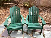 Front view of both green Adirondack chairs on patio