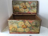 Front and top view of the wooden crate with lid open, showing colorful printed paper advertising featuring Pilot Bread and sailing ships.