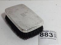 Side angle showing thick dense black bristles attached to the silver body of the brush.