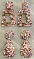 Two pairs of vintage pink rhinestone clip-on earrings laid flat on a surface showing front detail of rhinestones on gold-tone metal.