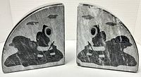 Pair of carved stone bookends depicting Inuit figure paddling a kayak, facing each other