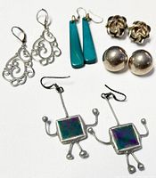 Overview of all five pairs of assorted sterling silver earrings in the lot, showing variety of styles including filigree, geometric drop, ball studs, and robot shapes.