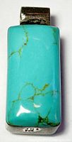 Front view of the pendant showing the rectangular turquoise stone with natural veining set in silver with a bail.