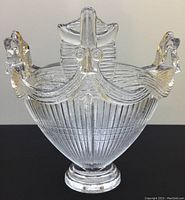 Full view of large clear crystal glass bowl with sculptural face and mustache design, showing ornate detailed rim and vertical ribbing.