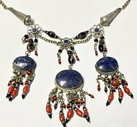 Full view of the old Tibetan silver necklace showing lapis lazuli stones, coral and black bead dangles with silver metalwork.