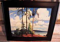 Framed art print on board showing a landscape with three tall trees, cloudy sky, and distant land, surrounded by a black frame
