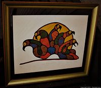 Full view of framed print showing colorful artistic depiction of loons, gold frame, and matting.