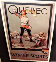 Framed Canadian Pacific Quebec winter sports travel poster showing two skiers in vintage attire against mountains.