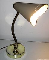 Mid-century modern figural bowling table lamp lit, showing the shade and base with bowler figurine detail.