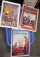 Three magazines stacked and displayed on a blue container showing the front covers.