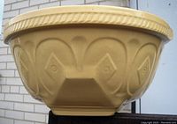 Side view showing embossed geometric and heart-shaped pattern on the beige ceramic mixing bowl exterior.