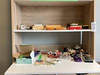 Shelf view showing various boxed games, clock, cassettes and instrument set