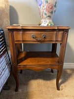 Front view of the wooden nightstand showing drawer and open shelf.