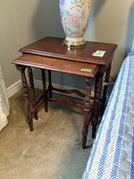 Two wooden nesting tables stacked together, showing overall size and composition.