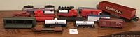 Photo showing all model train engines and freight cars together, including U.S. Army rail car and assorted cars.