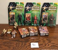 Star Wars action figures in packaging and loose figures laid on a table with three boxed 50-piece puzzles.