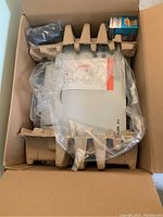 Top-down view of the Lexmark X73 printer inside the box with cardboard protective packaging and visible accessories.