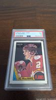 Photo of 1987 O-Pee-Chee Al MacInnis hockey card graded PSA 5 in protective case showing front side of card.