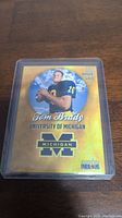 Front of 1999 Tom Brady University of Michigan football card showing player image and card details.