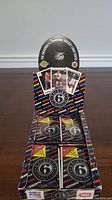 Display box showing multiple unopened packs of Original 6 hockey cards in black foil with colorful team names and logo.