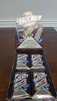 Display box with 4 sealed foil packs of 1990-91 Upper Deck NHL hockey cards visible inside.