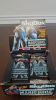 Photo of SkyBox Super Mario Bros. trading card box with 30 packs inside, box in worn condition showing some crease and age.
