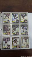Photo of hockey cards in a plastic sleeve album page, featuring 9 cards mostly Boston Bruins players.