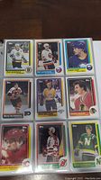 Photo showing nine 1986-87 Topps hockey cards including Ray Bourque, Pat LaFontaine, Lindy Ruff, Brad McCrimmon, Dave Hilliard, Denis Lavagne, Lanny McDonald, and Craig Leveseen.
