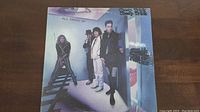 Front cover of Cheap Trick's 'All Shook Up' vinyl album showing band members in a surreal blue-themed setting.