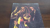 Front cover of Cheap Trick At Budokan vinyl album showing band members performing live in warm stage lighting.
