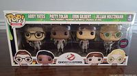 Front view of the Funko Pop 4-pack box featuring the 4 Ghostbusters characters: Abby Yates, Patty Tolan, Erin Gilbert, and Jillian Holtzmann.