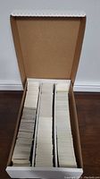 Photo of a large cardboard box filled tightly with three rows of cards stacked vertically, showing the large volume of cards in the lot.