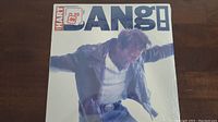 Front cover of Corey Hart Bang! vinyl record in shrink wrap with price sticker.