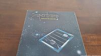 Front cover of Supertramp Crime of the Century vinyl album with stylized artwork of hands gripping bars in a starry night sky.