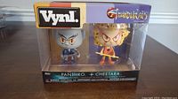 Front view of unopened Thundercats Vynl box with Panthro and Cheetara figures visible inside packaging.