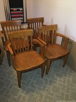 Four chairs arranged together on carpeted floor, angled view.