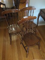 Set of three maple chairs arranged showing front and side views, all with similar wood finish and spindle backs.